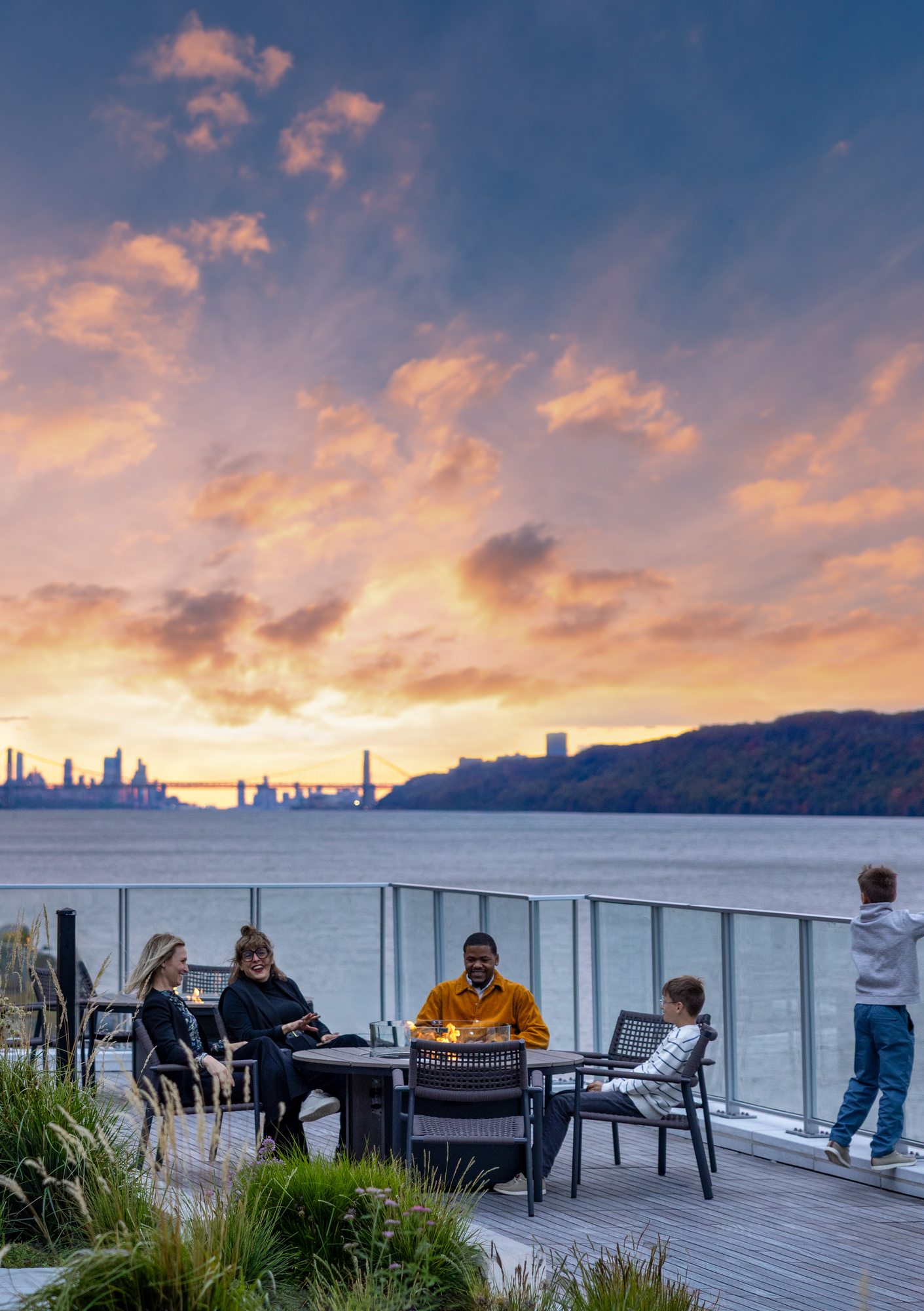 Residents around a fire pit on the terrace at sunset
